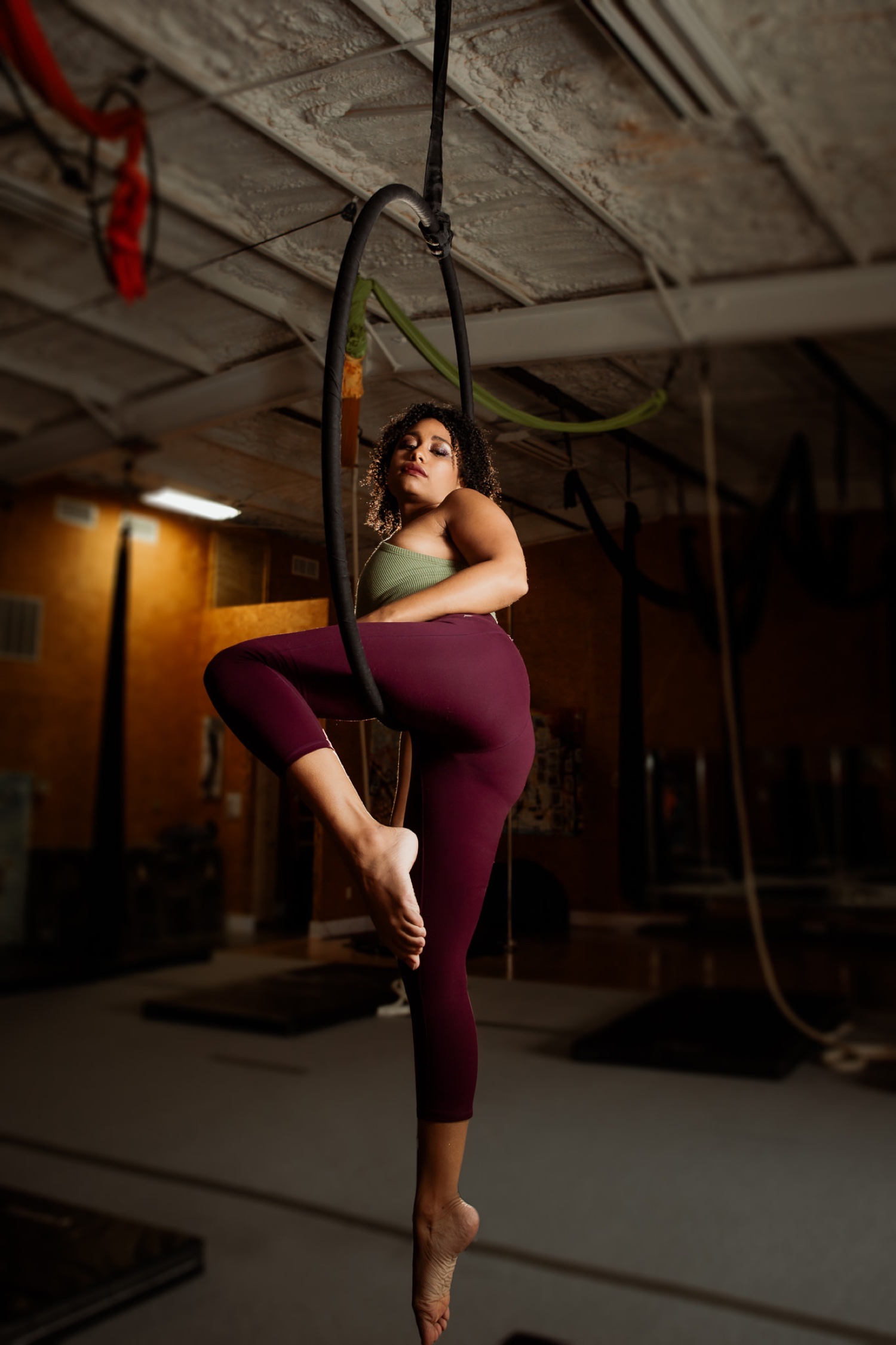 A female acrobat swings upside down from an aerial hoop Stock Photo - Alamy