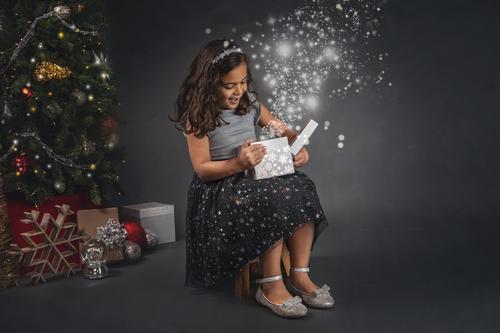 Premium Photo  The girl poses and takes a selfie near the christmas tree.  a woman congratulates a relative online by phone. she is holding a gift in  her hand and smiling.