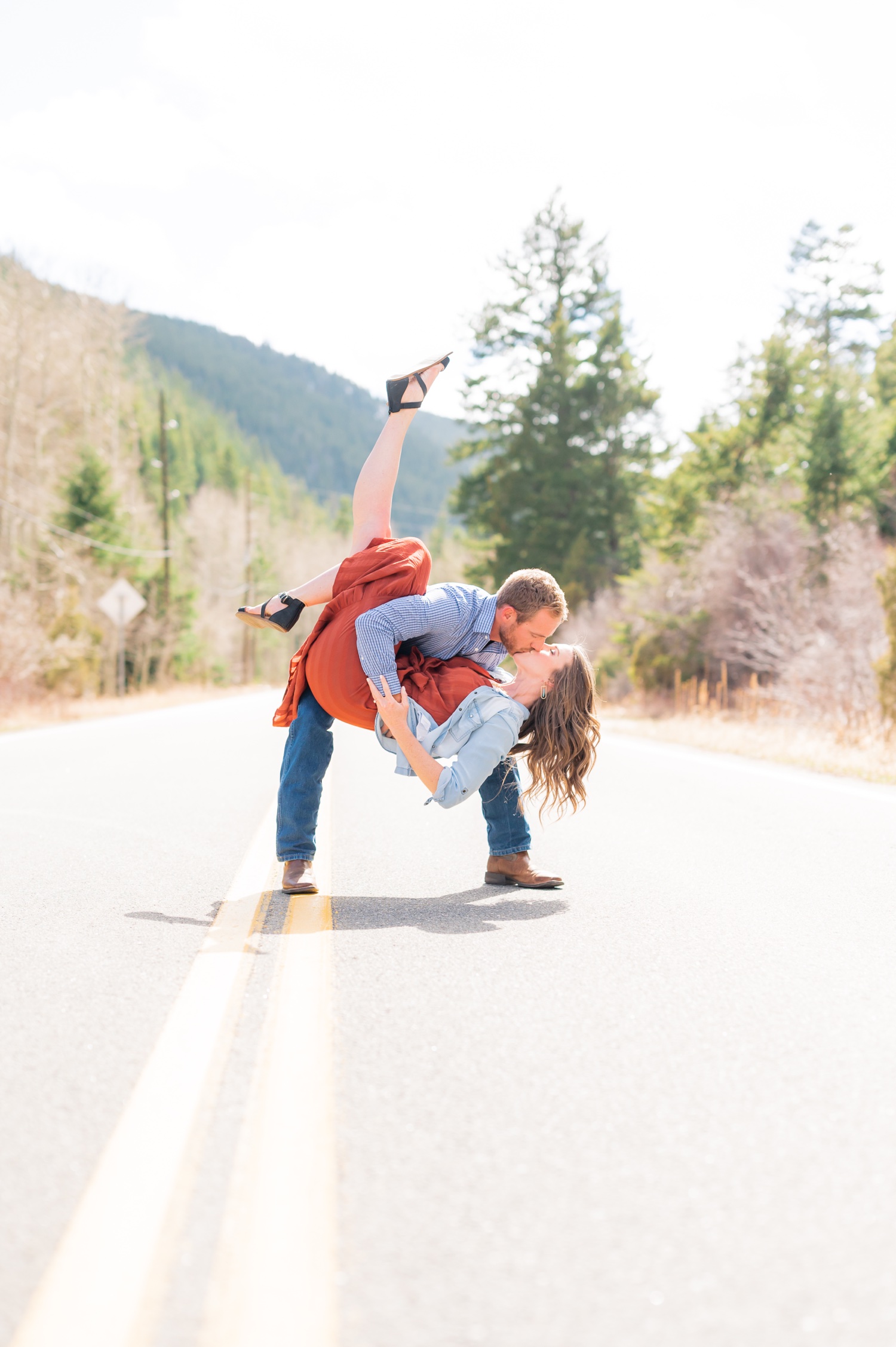 Side view of romantic couple in casual clothes hugging while standing on  remote empty road on dark alley stock photo