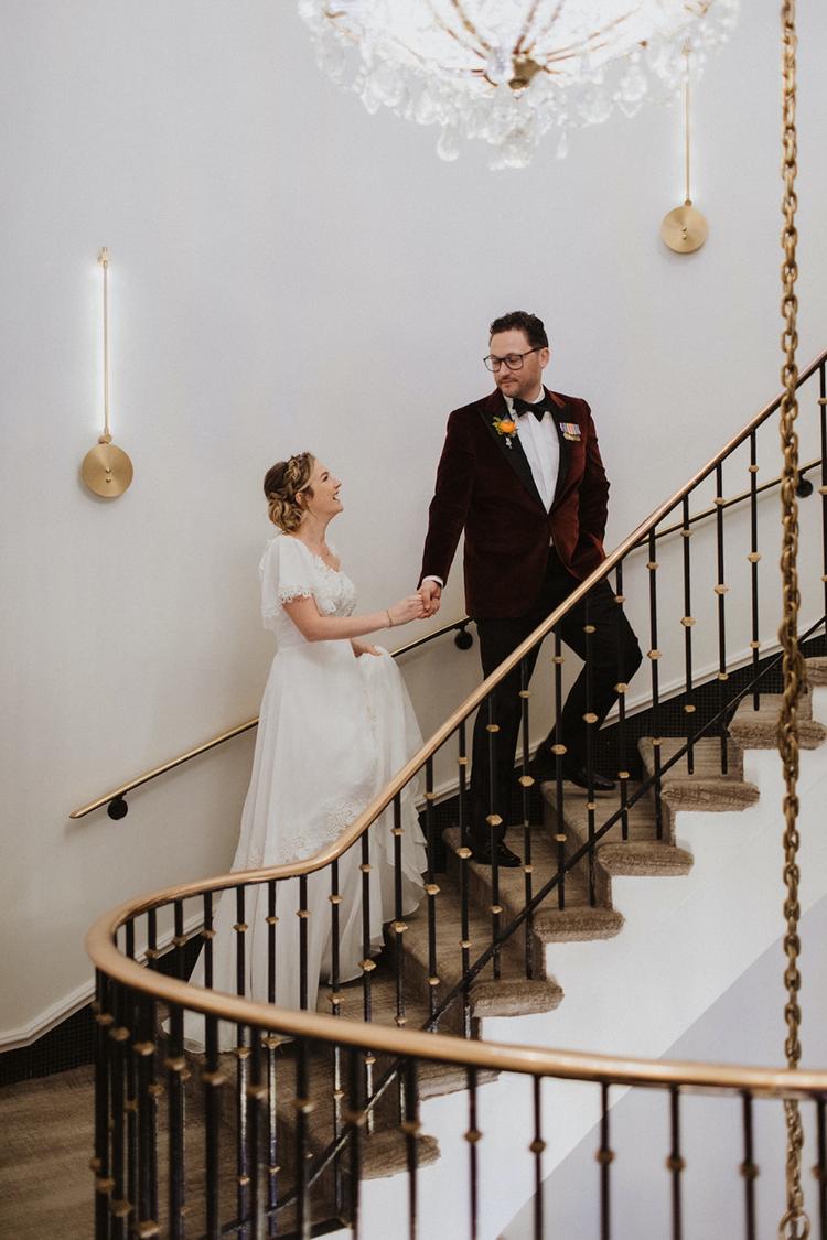 Couple walks up staircase under chandelier at Hotel Washington, Washington DC