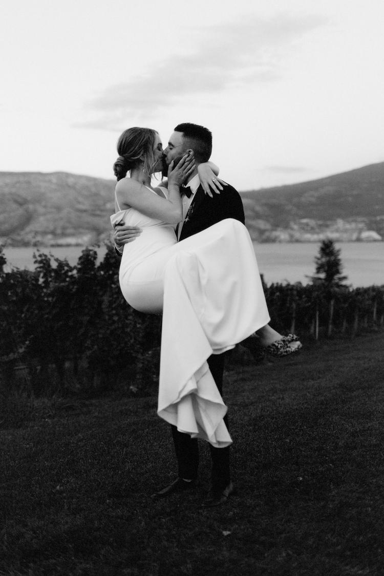 groom holding bride while kissing