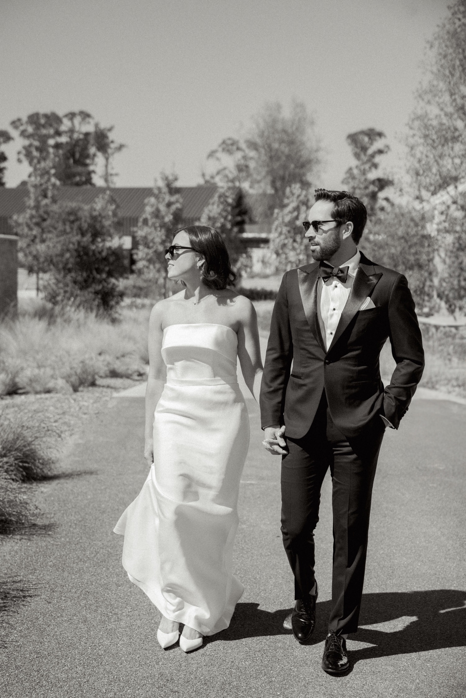 https://fetch.getnarrativeapp.com/static/84eaee5c-c132-445b-8f30-63f36282a9d9/bride-in-sunglasses-and-strapless-white-gown-walking-with-groom-on-Stanly-Ranch-wedding-day.jpg?w=1500