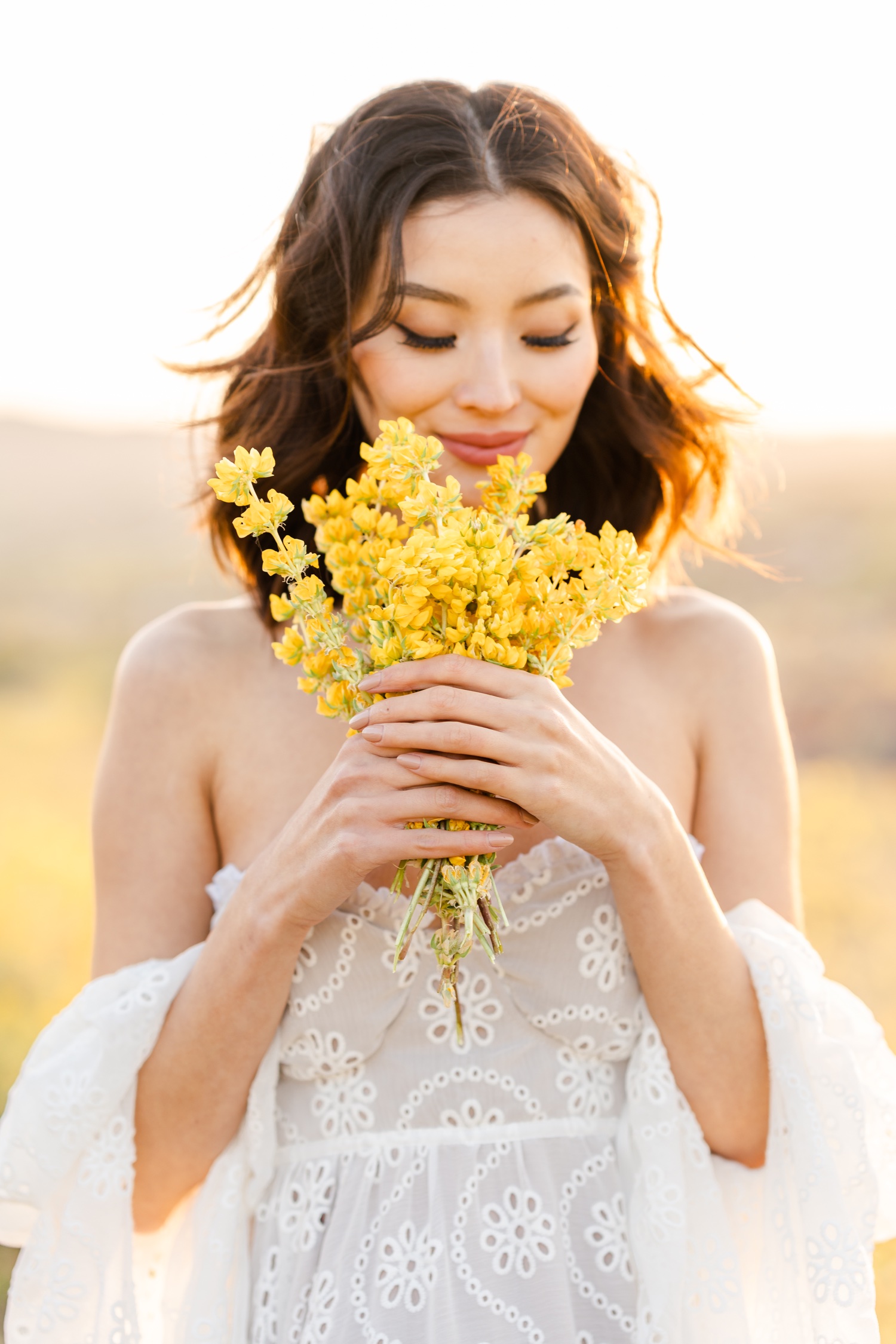A fashionable girl in a beautiful white dress poses with yellow dandelion  flowers in green foliage Stock Photo - Alamy