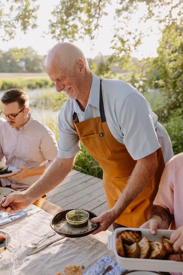 https://fetch.getnarrativeapp.com/static/bfd4dfda-d5cb-4113-a44d-e9bf44feb3b8/Sharing-a-meal-outdoors-on-the-marsh-in-the-lowcountry-while-home-chefs-wear-Hedley-&-Bennett-aprons.jpg?w=750